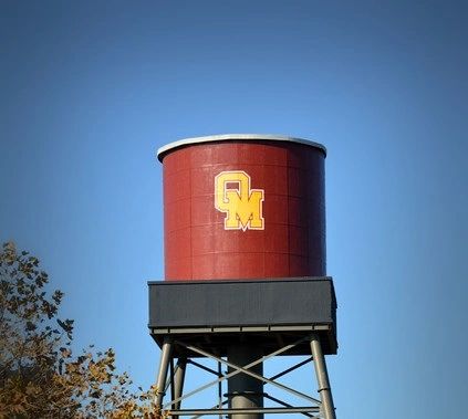 The historic Oakdale water tower rising above downtown rooftops