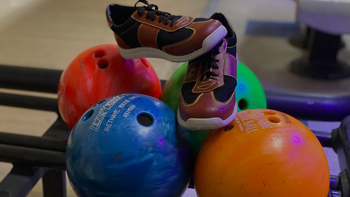 A bowler mid-release sending the ball down the lane
