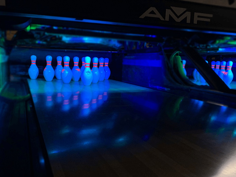 Bowlers under blacklight during Extreme Bowl glow bowling